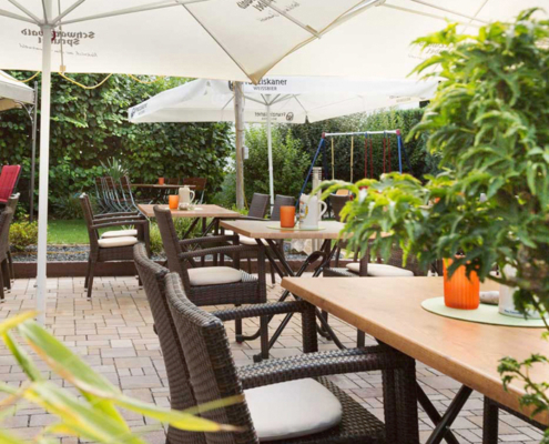 Biergarten mit schönen Schattenplätzen unter dem Sonnenschirm